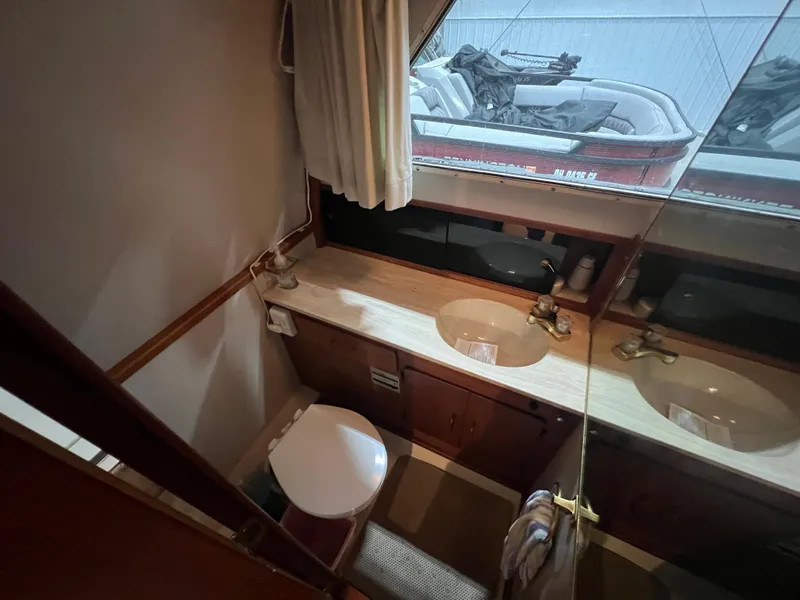 Slide: The Image of 1987 Tollycraft 30 Sport Cruiser bathroom with dual sinks and toilet. - 14
