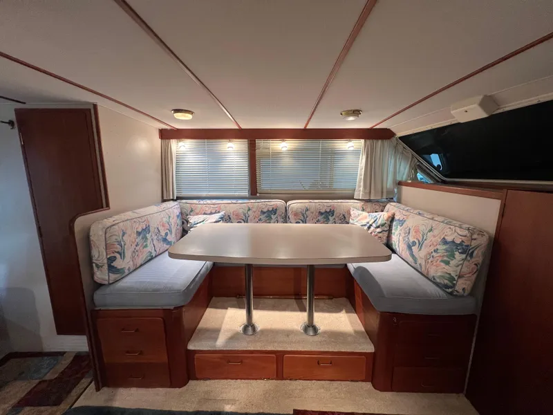 Slide: The Image of 1987 Tollycraft 30 Sport Cruiser interior with cozy dining area and floral upholstery. - 15