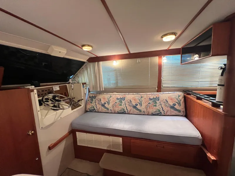 Slide: The Image of 1987 Tollycraft 30 Sport Cruiser interior with cushioned seating and helm station. - 16