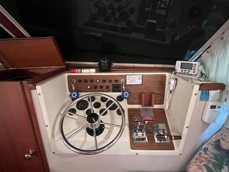 Slide: The Image of 1987 Tollycraft 30 Sport Cruiser helm with steering wheel, controls, and navigation instruments. - 17