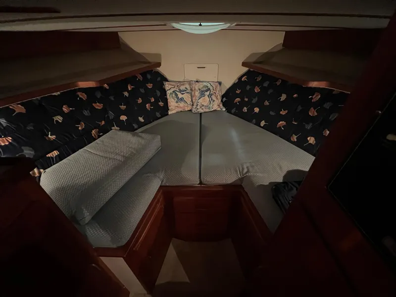 Slide: The Image of 1987 Tollycraft 30 Sport Cruiser cabin with cozy bedding and wooden interior. - 18