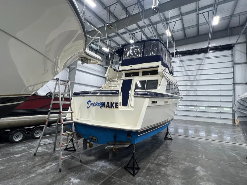 Slide: The Image of 1987 Tollycraft 30 Sport Cruiser in storage, rear view with ladder access. - 2
