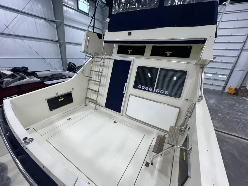 Slide: The Image of 1987 Tollycraft 30 Sport Cruiser in a spacious indoor storage facility. - 6