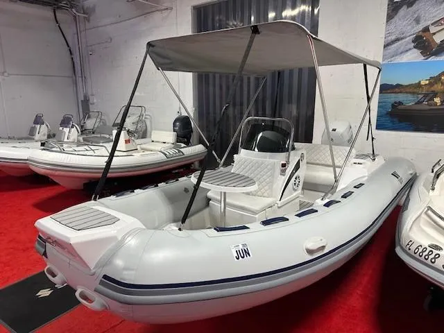 Slide: The Image of 2023 Tiger Marine SL 480 inflatable boat with canopy displayed indoors on red carpet. - 2
