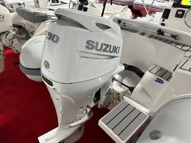 Slide: The Image of 2023 Tiger Marine SL 480 boat with Suzuki 90 outboard motor on red carpet display. - 3
