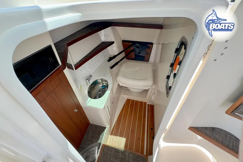 Slide: The Image of 2025 Grady-White Freedom 325 boat interior with sink, toilet, and wooden flooring. - 12