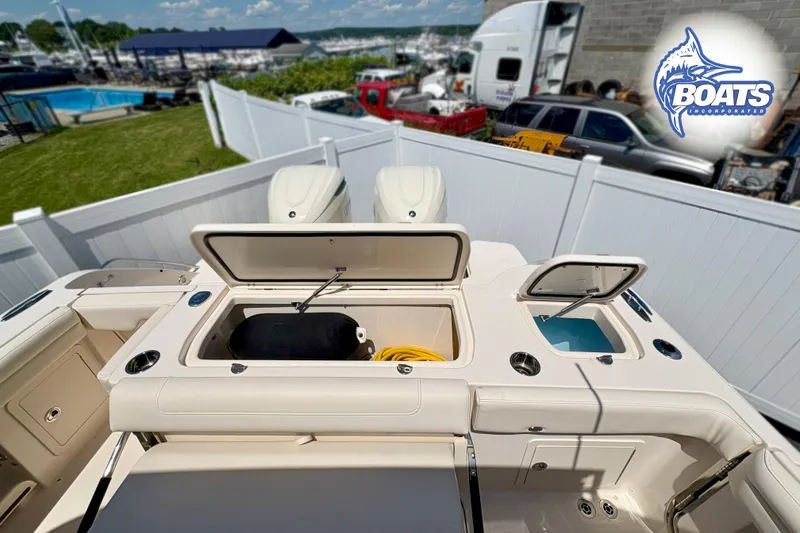 Slide: The Image of 2025 Grady-White Freedom 325 boat with open storage compartments, docked near marina. - 18