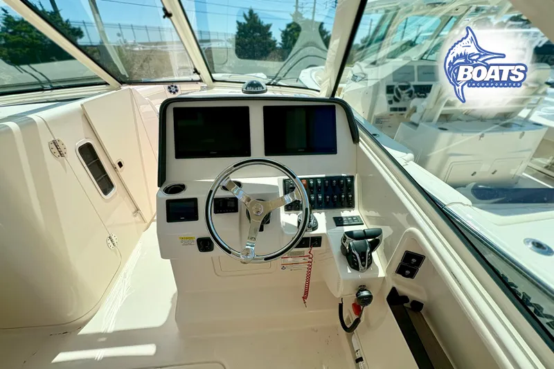 Slide: The Image of 2025 Grady-White Freedom 325 boat cockpit with steering wheel and control panel. - 9