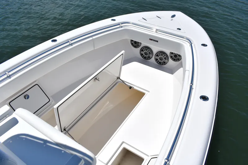 Slide: The Image of 2024 Contender 28 Tournament boat with open storage and speakers, on calm water. - 13
