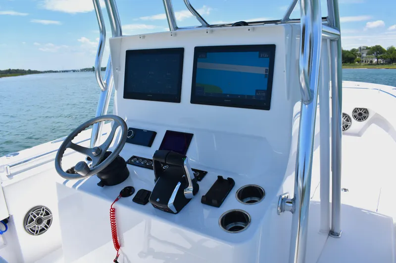Slide: The Image of 2024 Contender 28 Tournament boat console with dual screens and steering wheel on open water. - 19