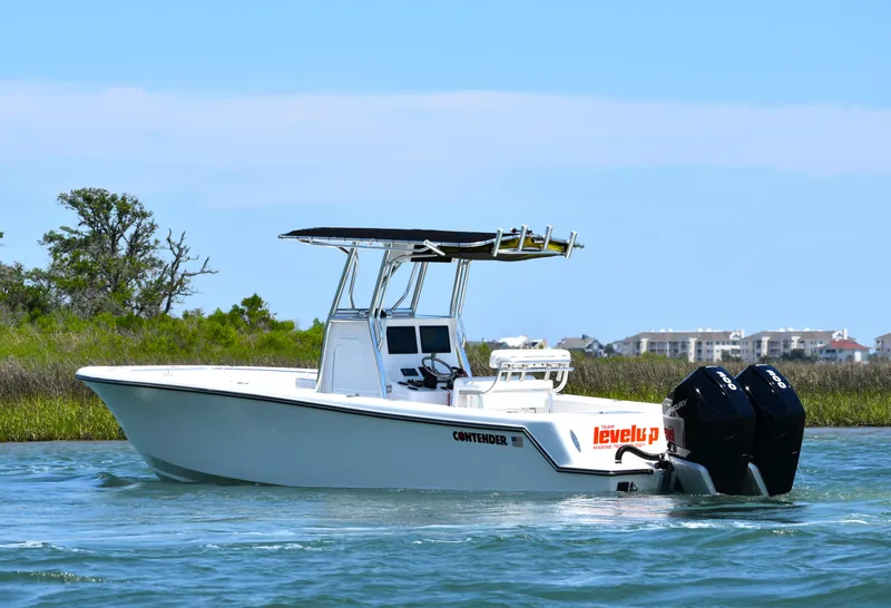 Slide: The Image of 2024 Contender 28 Tournament boat cruising on water with dual outboard engines. - 2