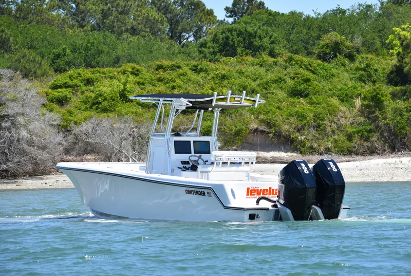 Slide: The Image of 2024 Contender 28 Tournament boat cruising near a lush, green shoreline. - 3