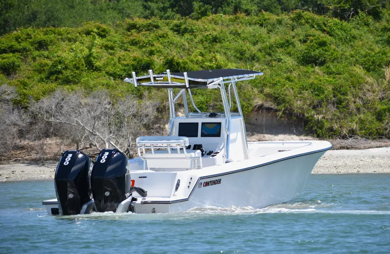 Slide: The Image of 2024 Contender 28 Tournament boat cruising on water with twin outboard engines. - 4