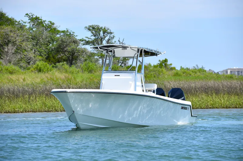 Slide: The Image of 2024 Contender 28 Tournament boat cruising on a calm waterway with lush greenery. - 8