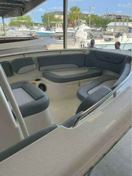 Slide: The Image of 2022 NauticStar 2102 Legacy boat interior with cushioned seating, docked at marina. - 12