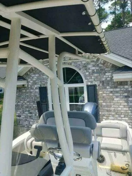 Slide: The Image of 2022 NauticStar 2102 Legacy boat with seating, parked near a brick house. - 15