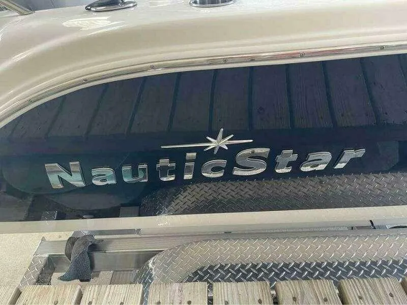 Slide: The Image of 2022 NauticStar 2102 Legacy boat with logo on the side, docked on a metal platform. - 9