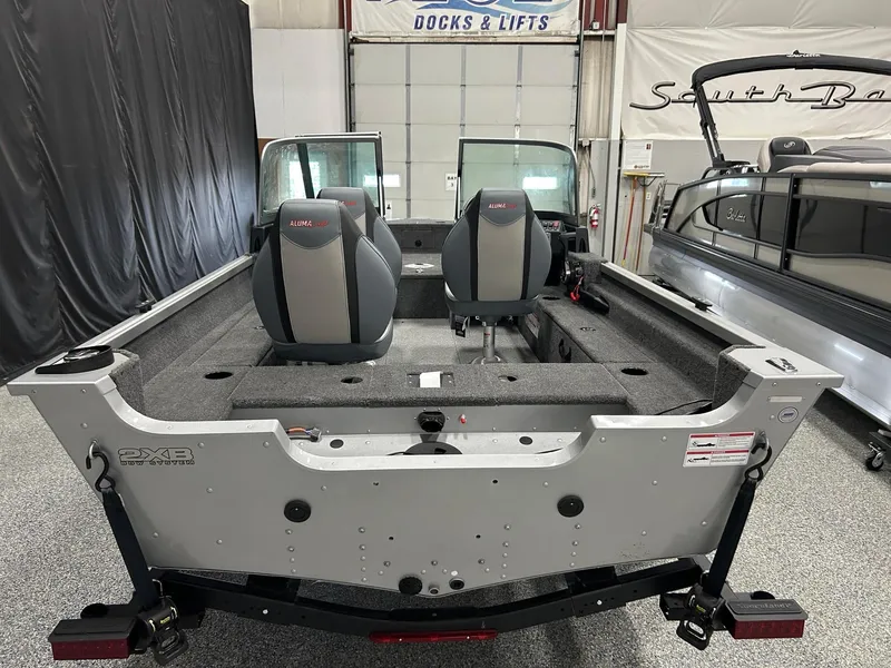 Slide: The Image of 2024 Alumacraft Classic 165 Sport boat interior with dual seats in a showroom. - 5