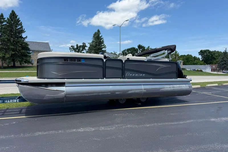 The Image of 2022 Premier 210 Sunspree pontoon boat parked on asphalt under a clear blue sky. - 0