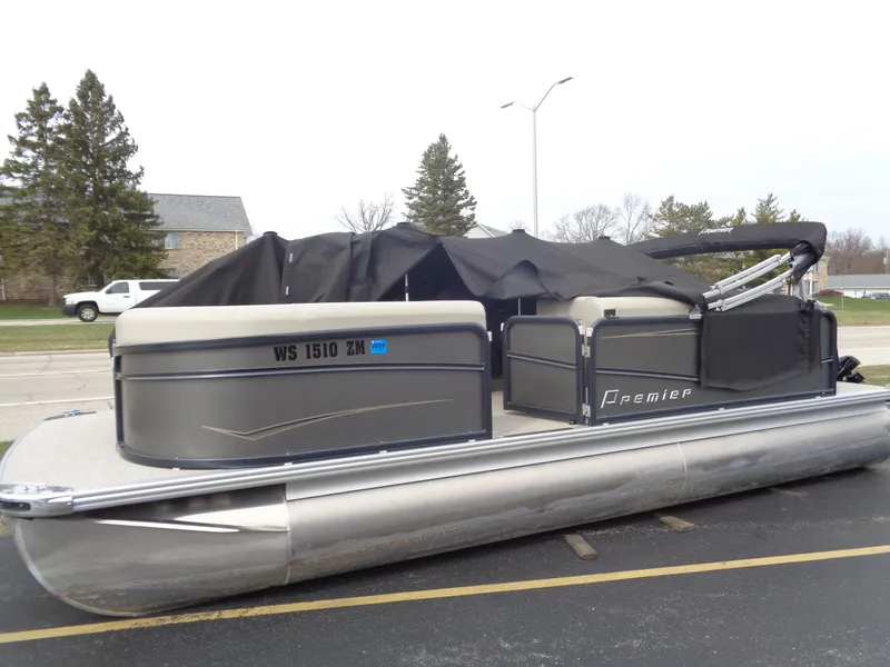 Slide: The Image of 2022 Premier 210 Sunspree boat seat storage compartment with open lid and metal poles. - 17