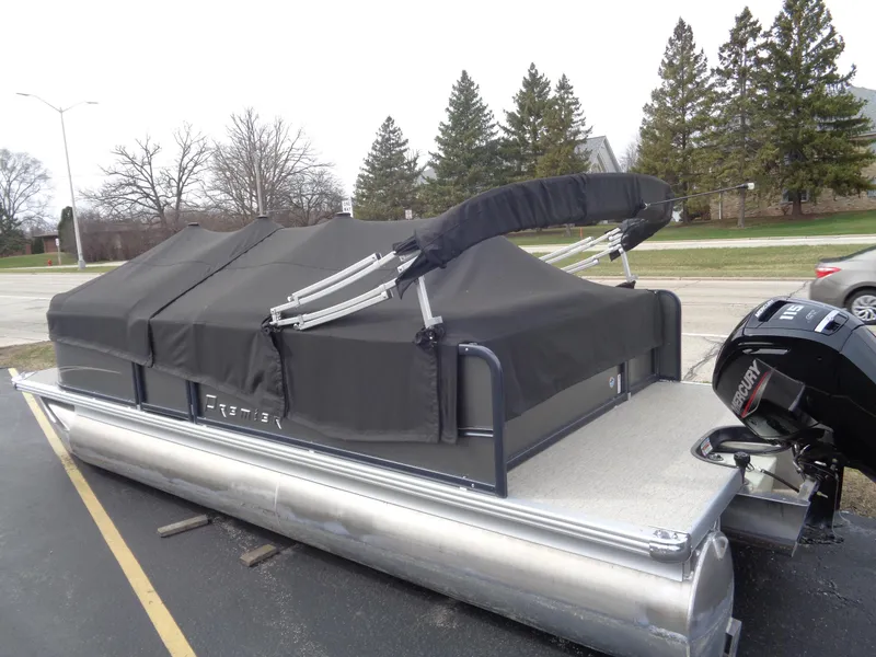 Slide: The Image of 2022 Premier 210 Sunspree boat with a shiny black outboard motor. - 18