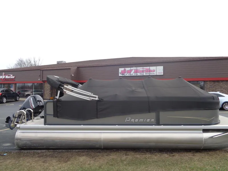 Slide: The Image of 2022 Premier 210 Sunspree pontoon boat with cover, parked outside a marine store. - 23