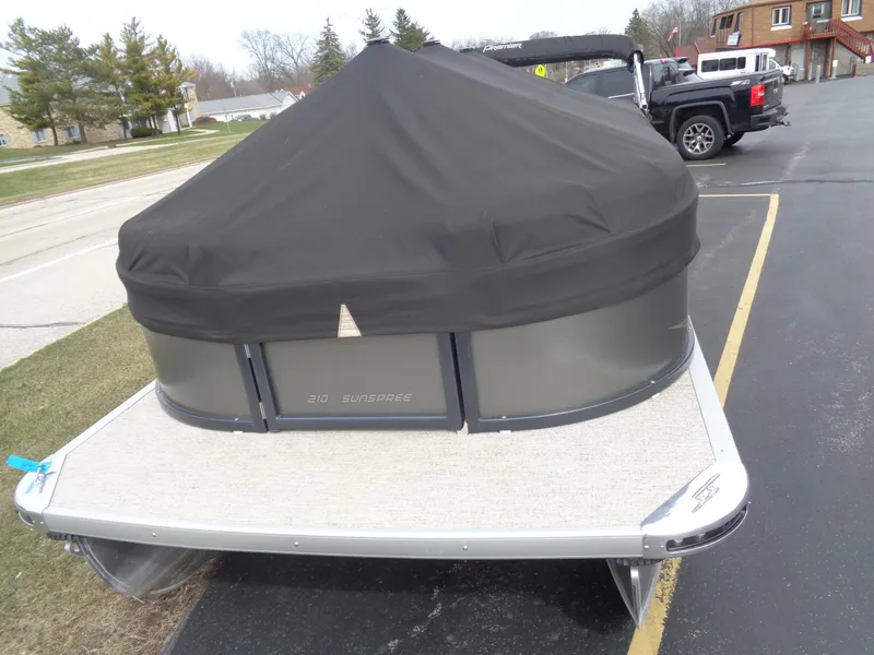 Slide: The Image of 2022 Premier 210 Sunspree pontoon boat interior with gray seating and open gate. - 3