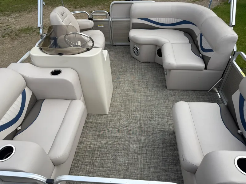 Slide: The Image of 2016 Apex Marine Qwest Adventure 7516 pontoon boat interior with plush seating and helm. - 10