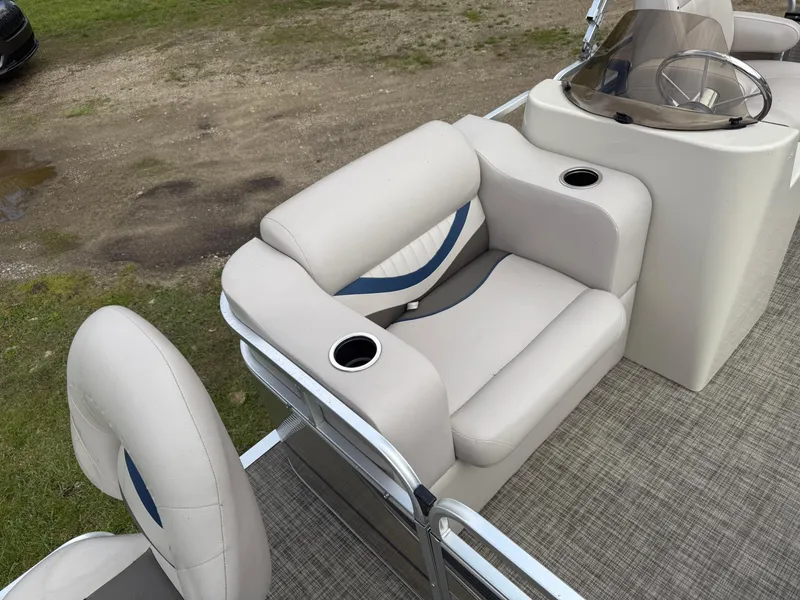 Slide: The Image of 2016 Apex Marine Qwest Adventure 7516 pontoon boat interior with plush seating and cup holders. - 12
