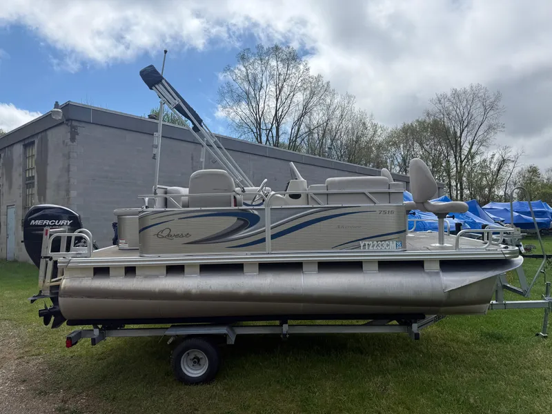 Slide: The Image of 2016 Apex Marine Qwest Adventure 7516 pontoon boat on trailer, parked outdoors. - 2