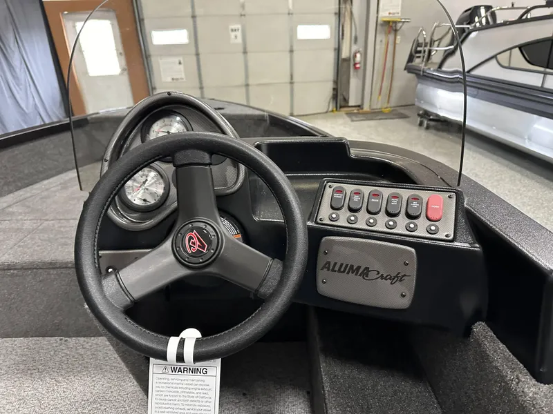 Slide: The Image of 2024 Alumacraft Classic 165 SC boat interior with four cushioned seats and steering console. - 16