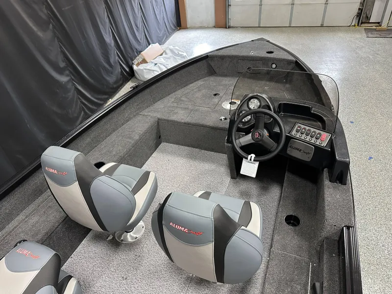 Slide: The Image of 2024 Alumacraft Classic 165 SC boat interior with gray seating and carpeted flooring. - 17