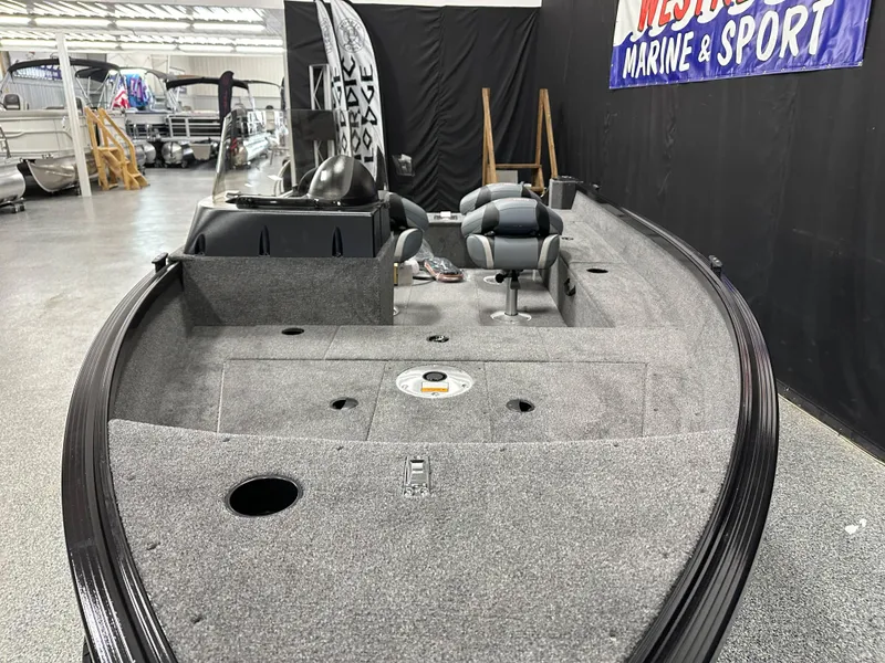 Slide: The Image of 2024 Alumacraft Classic 165 SC boat interior with carpeted deck and storage compartments. - 9