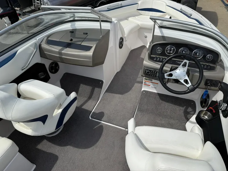 Slide: The Image of Interior of a 2012 Regal 2000 Bowrider boat with white seating and modern dashboard. - 11