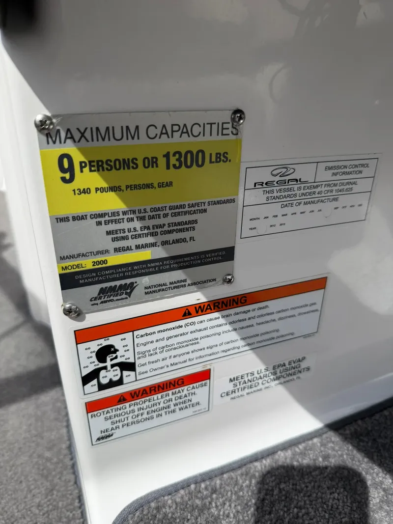 Slide: The Image of Capacity and safety labels on a 2012 Regal 2000 Bowrider boat, maximum 9 persons or 1300 lbs. - 12