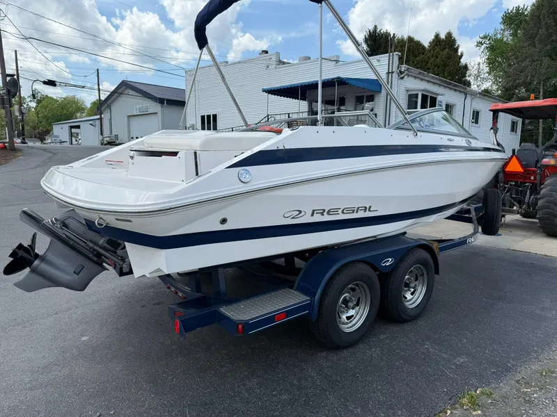 Slide: The Image of 2012 Regal 2000 Bowrider boat on trailer, parked outdoors, showcasing sleek design. - 4