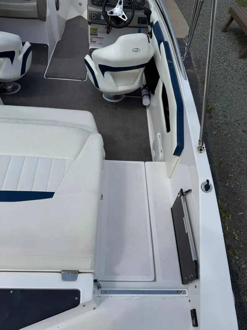 Slide: The Image of 2012 Regal 2000 Bowrider interior with white and blue seating, steering wheel, and carpeted floor. - 9