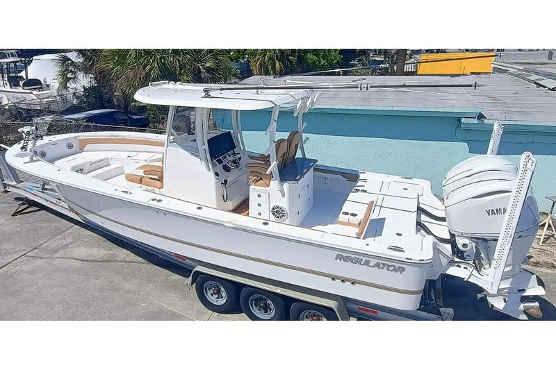 Slide: The Image of 2025 Regulator 30XO boat on trailer, featuring Yamaha engines, parked outdoors. - 1