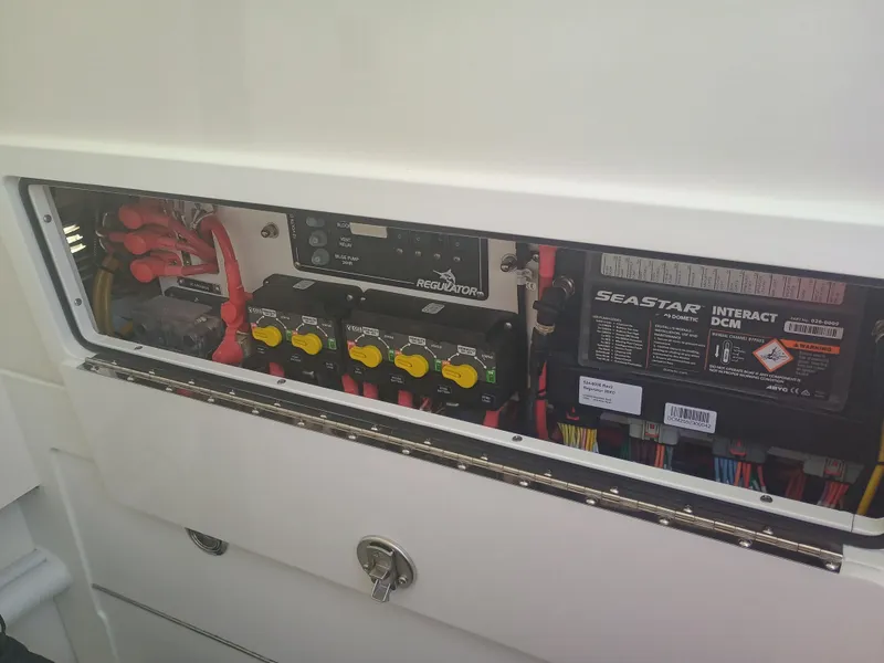 Slide: The Image of Electrical panel of 2025 Regulator 30XO boat, featuring SeaStar Interact DCM and wiring components. - 16