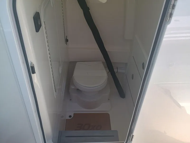 Slide: The Image of Interior of 2025 Regulator 30XO boat featuring a compact marine toilet. - 18