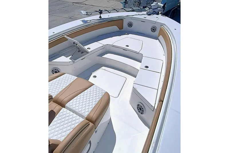Slide: The Image of 2025 Regulator 30XO boat interior with tan and white seating, featuring storage compartments and speakers. - 4