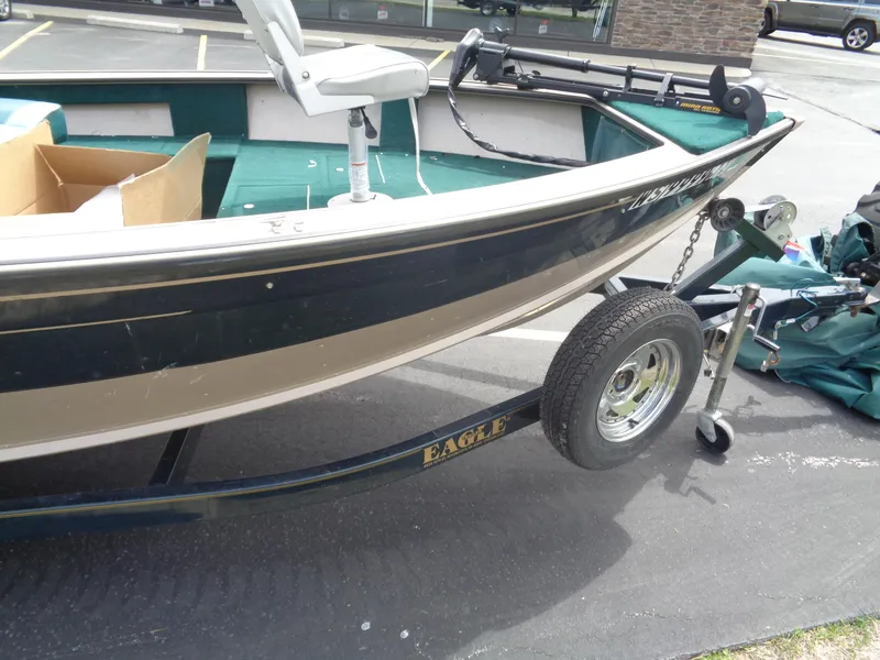Slide: The Image of 1999 Lund 1650 Angler boat on trailer, featuring green interior and Eagle trailer branding. - 12