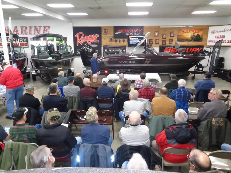 Slide: The Image of Audience attending a boat presentation in a showroom with various models displayed. - 15