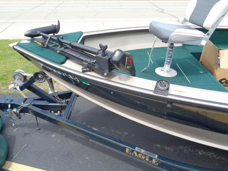 Slide: The Image of 1999 Lund 1650 Angler boat on trailer, featuring green interior and mounted trolling motor. - 2