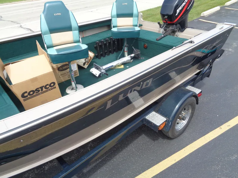 Slide: The Image of 1999 Lund 1650 Angler boat with dual seats and a Mercury outboard motor. - 3