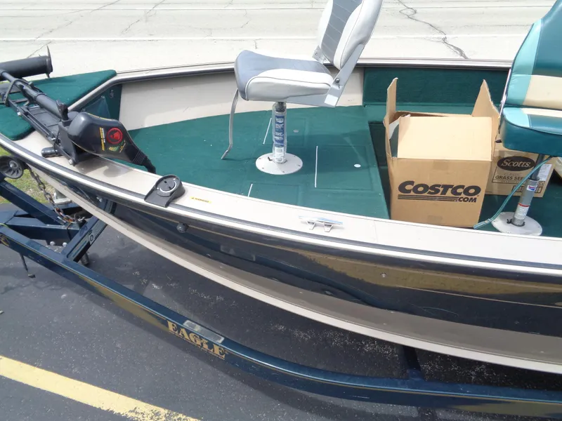 Slide: The Image of 1999 Lund 1650 Angler boat with green interior and Costco box on deck. - 4