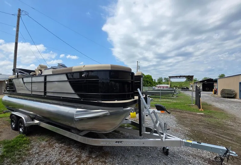 Slide: The Image of 2025 Veranda VR22RC XL Tri-Toon boat on trailer, parked outdoors under cloudy sky. - 11
