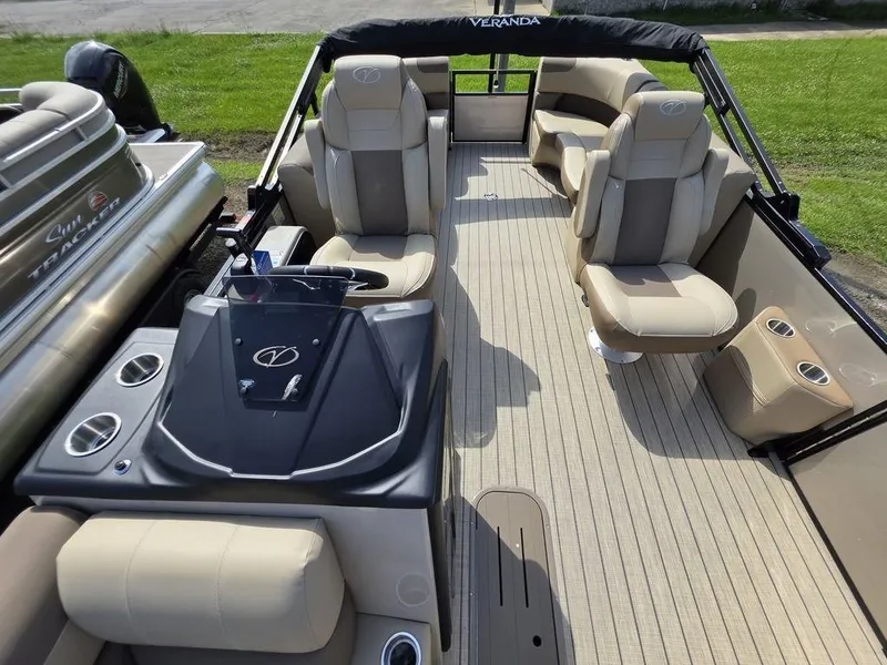 Slide: The Image of 2025 Veranda VR22RC XL Tri-Toon boat interior with beige seating and modern helm. - 17
