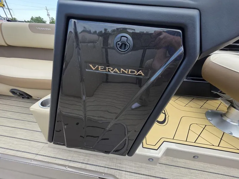 Slide: The Image of 2025 Veranda VR22RC XL Tri-Toon boat interior with sleek black panel and beige seating. - 22