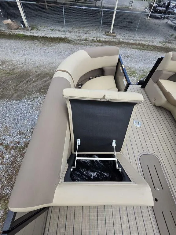 Slide: The Image of 2025 Veranda VR22RC XL Tri-Toon with open storage compartment on beige seating. - 26